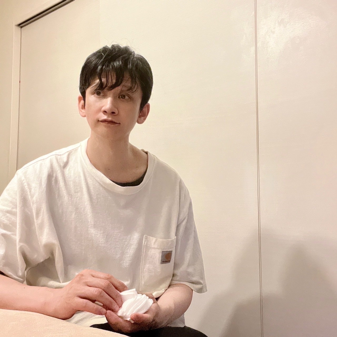 ムーンテッド(MoonTed)の日記より、施術台の横に座り、手に白い布を持つムーンテッド(MoonTed)のセラピストAKI。白いTシャツ姿