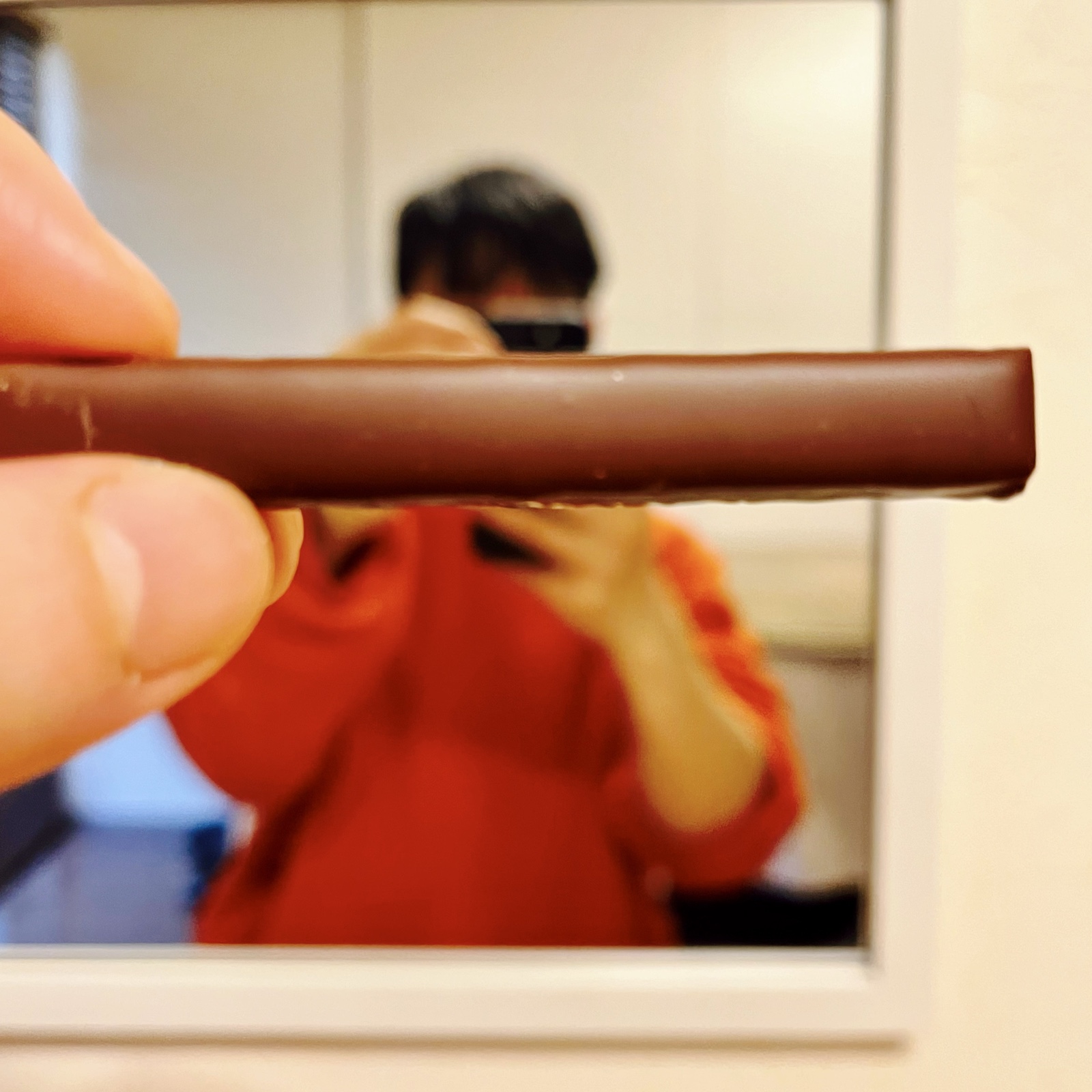ムーンテッド（MoonTed）の日記より、指でつまんだスティック状のシトロンジェット。背後の鏡に、写真を撮るムーンテッド（MoonTed）のセラピストAKI