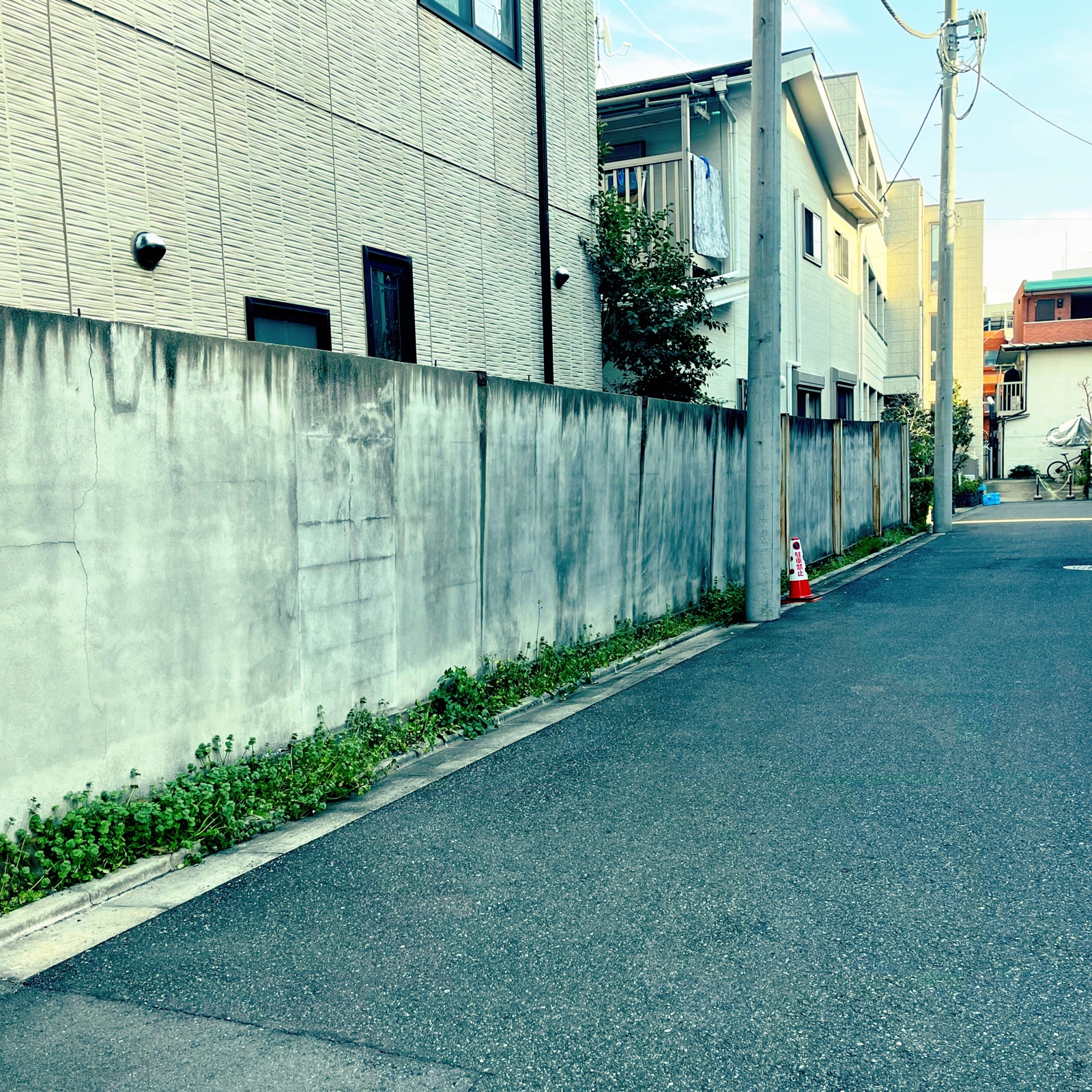 ムーンテッド(MoonTed)の日記より、代々木八幡の住宅街の路地。長いコンクリート塀と電柱が続く
