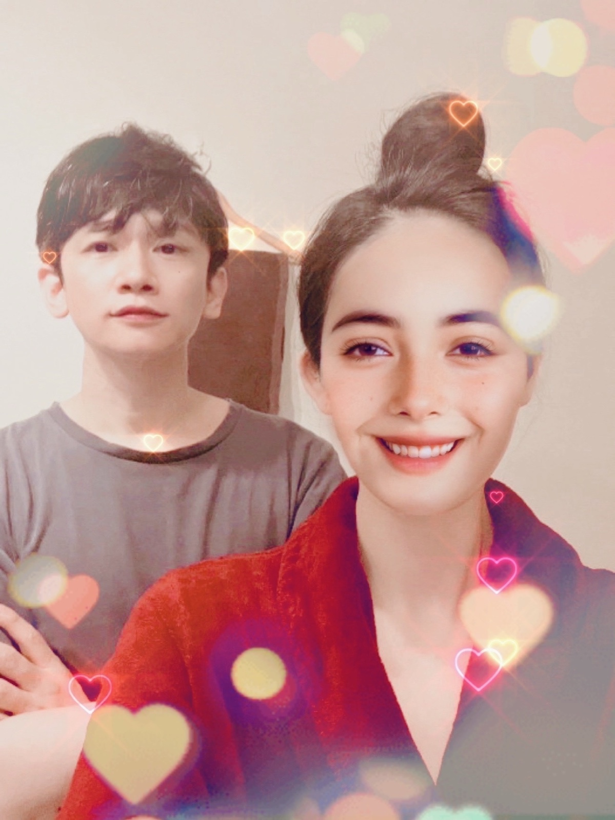 ムーンテッド(MoonTed)の日記より、ハートのエフェクトがかかった2ショット。赤いガウン姿でお団子ヘアの女性と、後ろに立つムーンテッド(MoonTed)のセラピストAKI