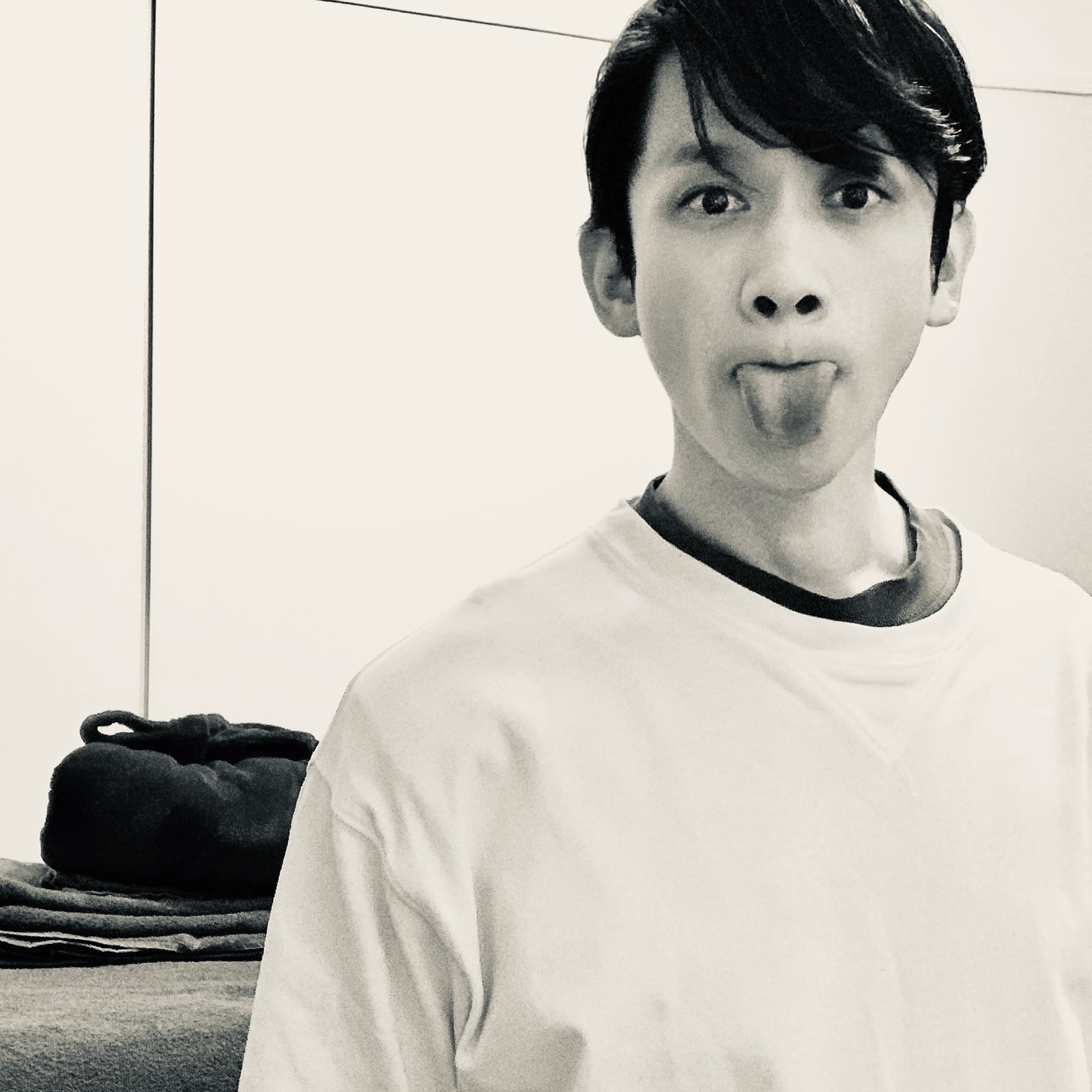 MoonTed Diary: Therapist AKI sticking out the tongue in a black-and-white photo, folded towels on the treatment bed behind