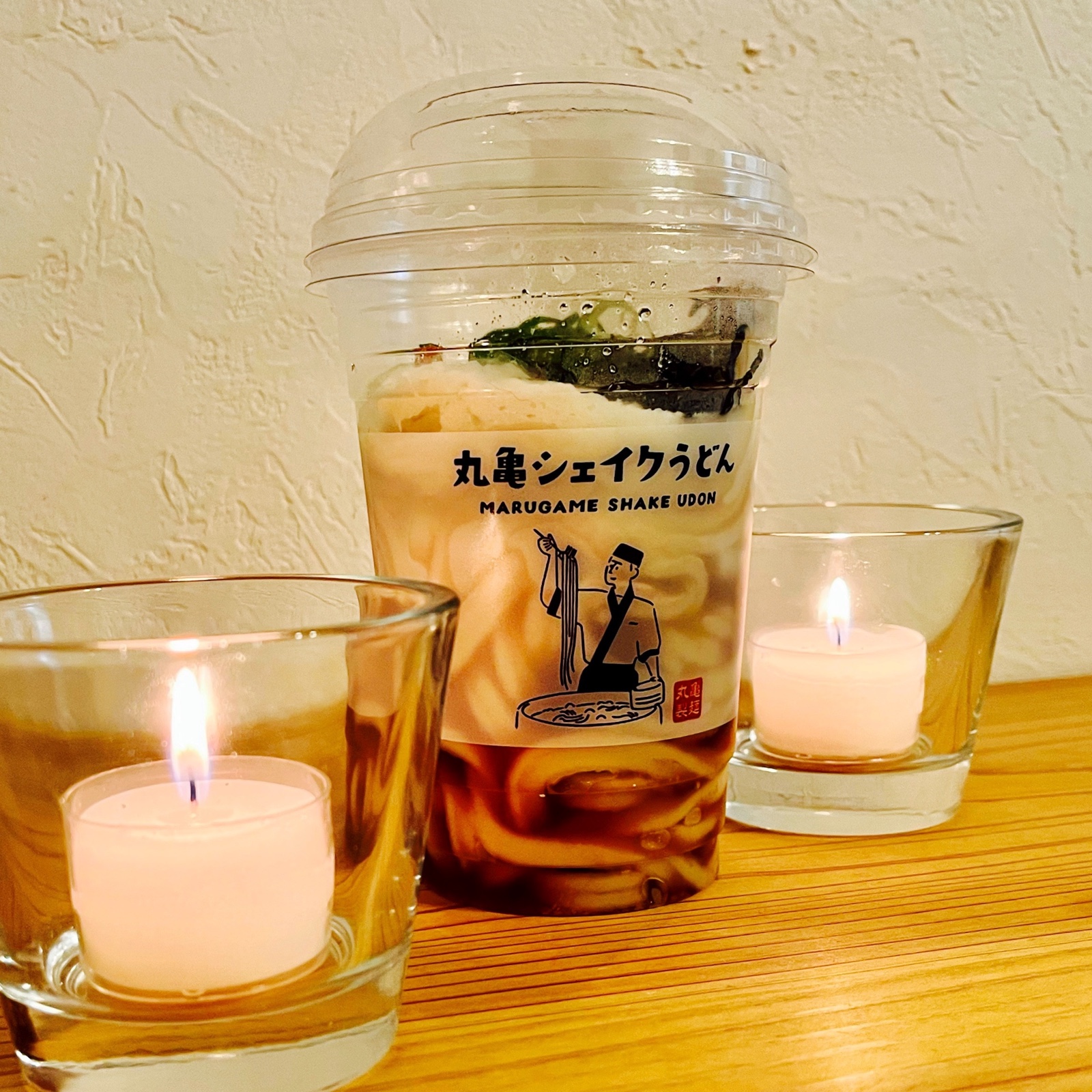 ムーンテッド(MoonTed)の日記より、丸亀製麺の「丸亀シェイクうどん」のカップ。両側にキャンドル