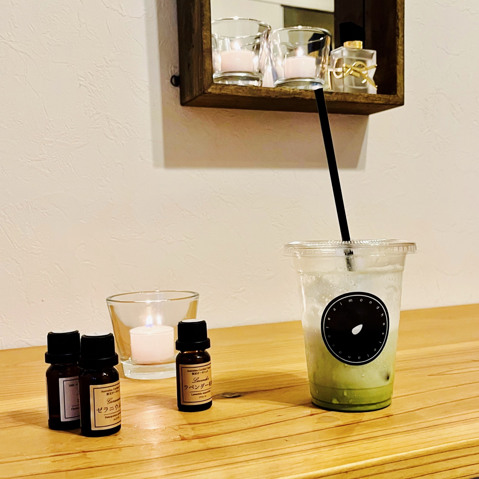 ムーンテッド（MoonTed）の日記より、プラスチックカップのアイス抹茶ラテと、精油の小瓶、キャンドル