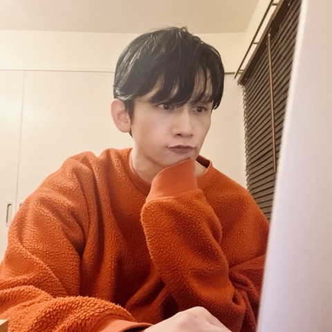 ムーンテッド（MoonTed）の日記より、頬杖をついて画面を見つめるムーンテッド（MoonTed）のセラピストAKI。オレンジのセーター姿