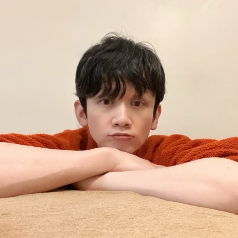 ムーンテッド（MoonTed）の日記より、施術台に腕を組んで、あごをのせるムーンテッド（MoonTed）のセラピストAKI。オレンジのセーター姿