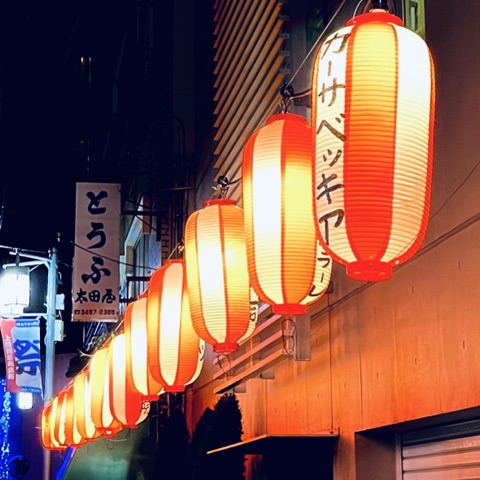 ムーンテッド（MoonTed）の日記より、代々木上原商店街に並ぶ提灯。夜の路地に灯る赤い光