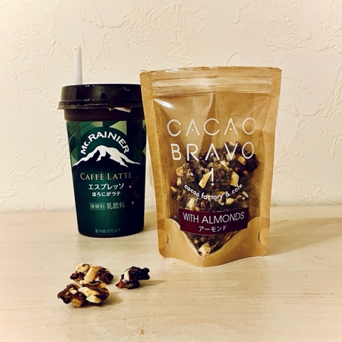 ムーンテッド（MoonTed）の日記より、カカオブラボーのニブシュガー（アーモンド入り）の袋と、カップのカフェラテ。手前にニブシュガーのかけら