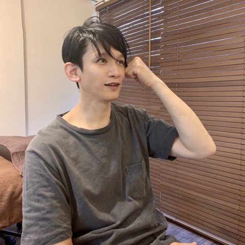 ムーンテッド（MoonTed）の日記より、髪に手をやり、横を向いて笑うムーンテッド（MoonTed）のセラピストAKI。グレーのTシャツ姿
