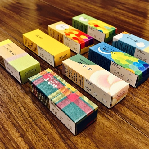 ムーンテッド（MoonTed）の日記より、並べた虎屋の小形羊羹。色とりどりの日本画のパッケージと、伊勢丹タータン柄の箱