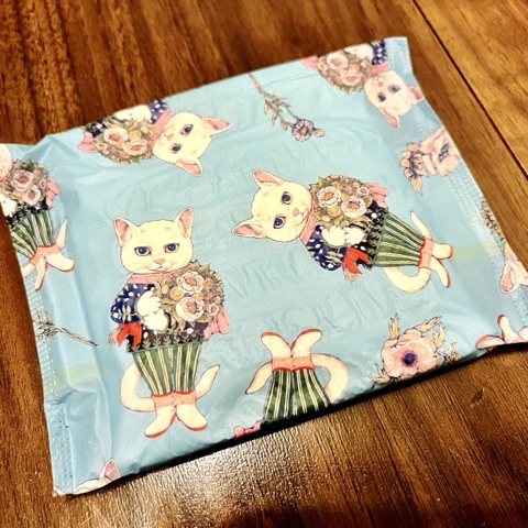 ムーンテッド（MoonTed）の日記より、ヒグチユウコさんが描いた、花束を抱えた猫柄のナプキンの個包装