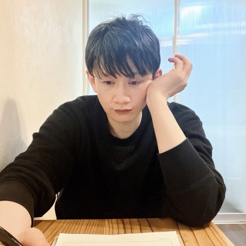 ムーンテッド（MoonTed）の日記より、机に頬杖をつき、視線を落とすムーンテッド（MoonTed）のセラピストAKI。黒いニット姿