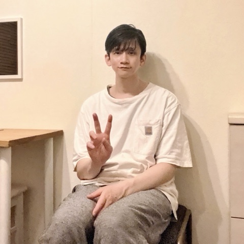 ムーンテッド（MoonTed）の日記より、椅子に座ってピースサインをするムーンテッド（MoonTed）のセラピストAKI。白いTシャツ姿