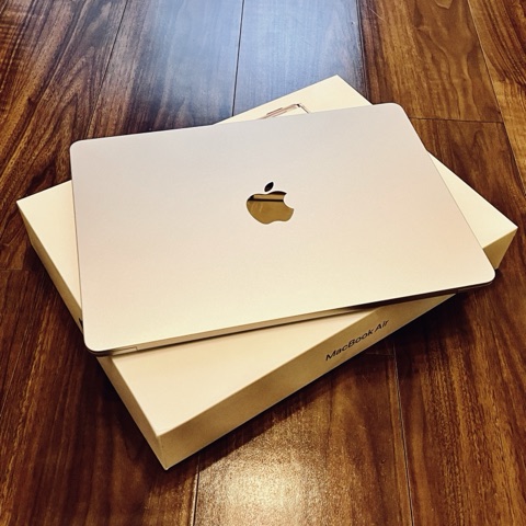 ムーンテッド（MoonTed）の日記より、箱の上に置いた新品のMacBook Air。木の床の上