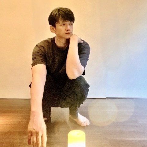 ムーンテッド（MoonTed）の日記より、素足でしゃがみ、頬杖をついて横を見るムーンテッド（MoonTed）のセラピストAKI。手前にキャンドルの灯り