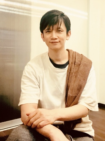 ムーンテッド（MoonTed）の日記より、肩に茶色のタオルをかけ、手を組んで微笑むムーンテッド（MoonTed）のセラピストAKI。白いTシャツ姿