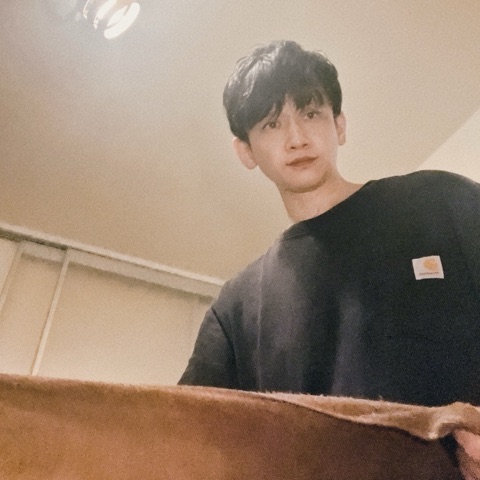 MoonTed Diary: Therapist AKI seen from a client's view on the treatment bed, holding a brown towel, in a black T-shirt
