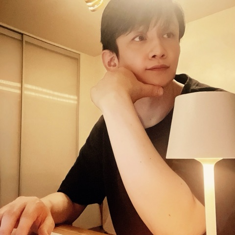 MoonTed Diary: Therapist AKI resting chin on hand beside a white lamp, looking up