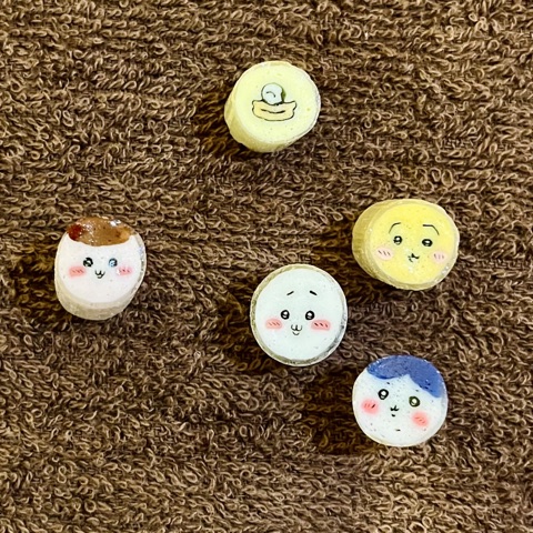 ムーンテッド（MoonTed）の日記より、茶色のタオルの上に並ぶ5粒のキャンディー。断面にちいかわのキャラクターの顔が描かれている