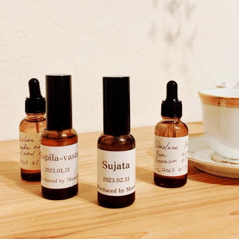 ムーンテッド（MoonTed）の日記より、「Sujata」と「Kapila-vastu」のラベルの香水瓶。手前にスクワランオイルのスポイト瓶、奥にティーカップ
