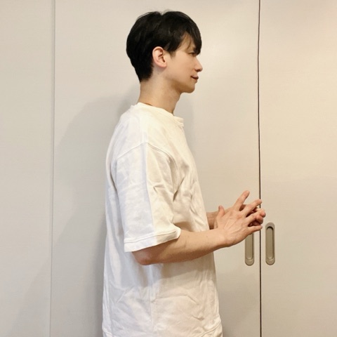 ムーンテッド（MoonTed）の日記より、横向きで手を組んで立つムーンテッド（MoonTed）のセラピストAKI。白いTシャツ姿